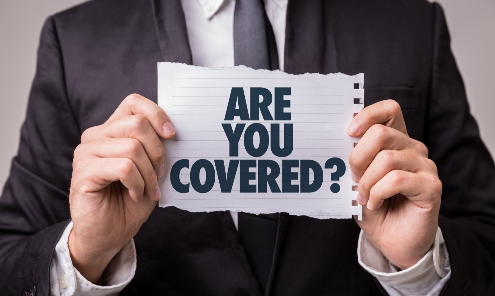 Insurance adjuster holding an ‘Are You Covered?’ sign